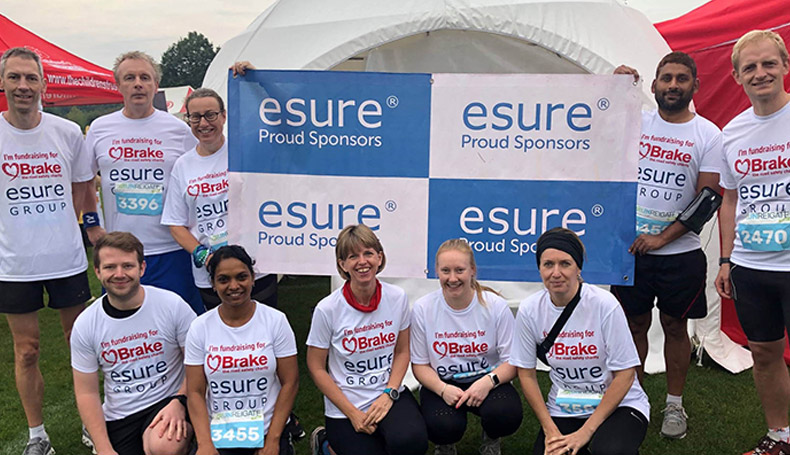 esure colleagues in running gear with esure banner behind them